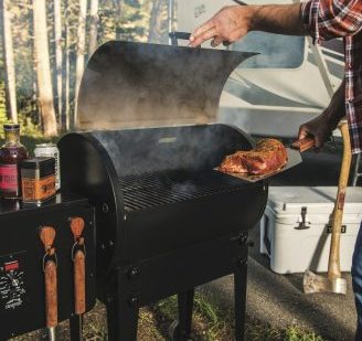 Man putting a steak on the Traeger Grill